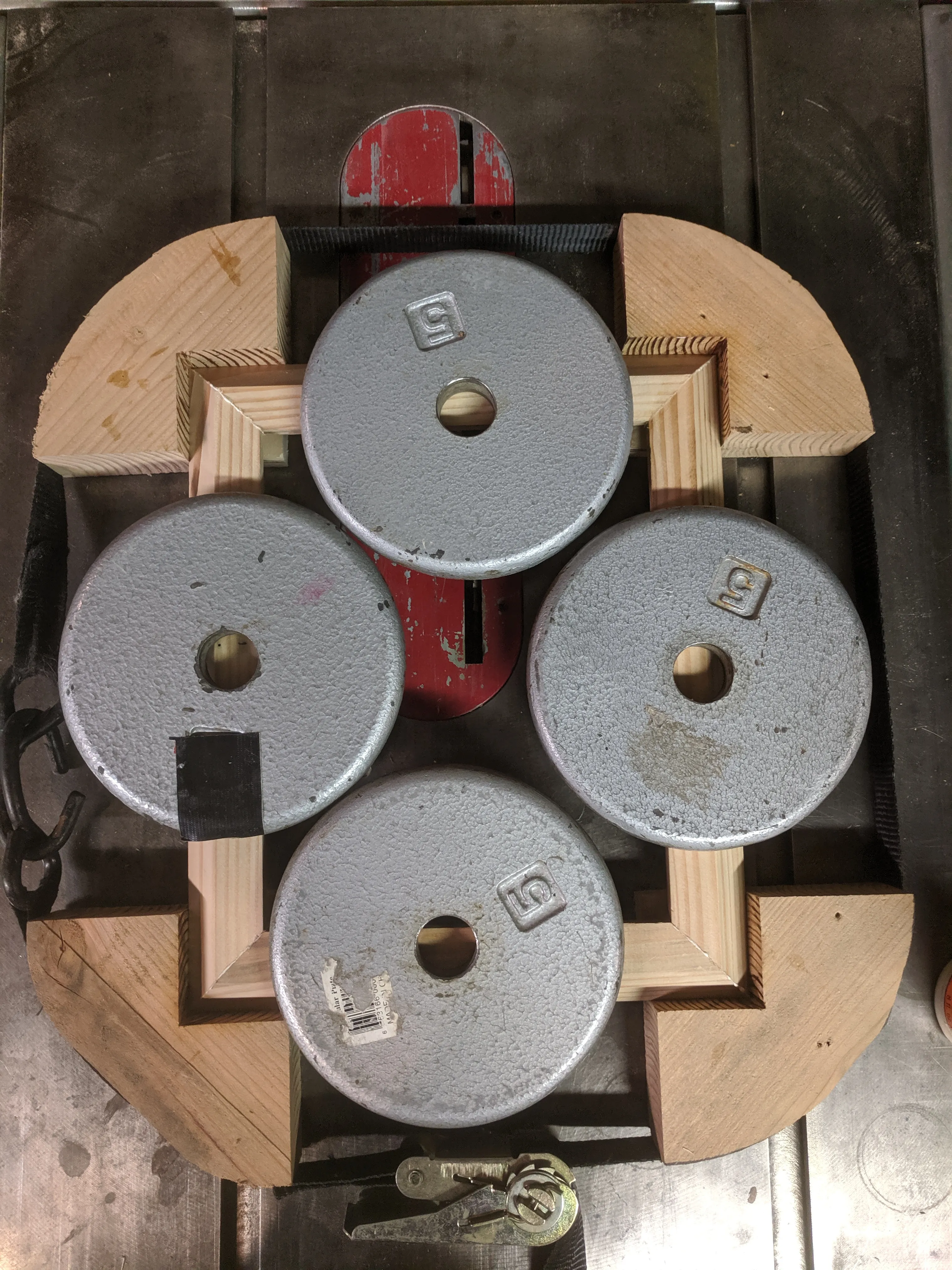 Doesn't have to be high tech to work Wooden corner blocks with a strap around them clamp the frame in place while weights on top keep it from buckling