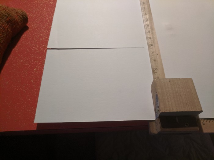 Two yardsticks held square to each other with a razor blade attached to a piece of work sliding along one