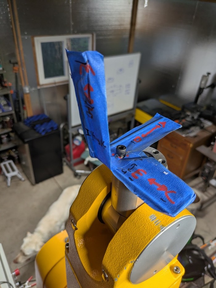arrows and letters written on tape on wires on the end of the robot